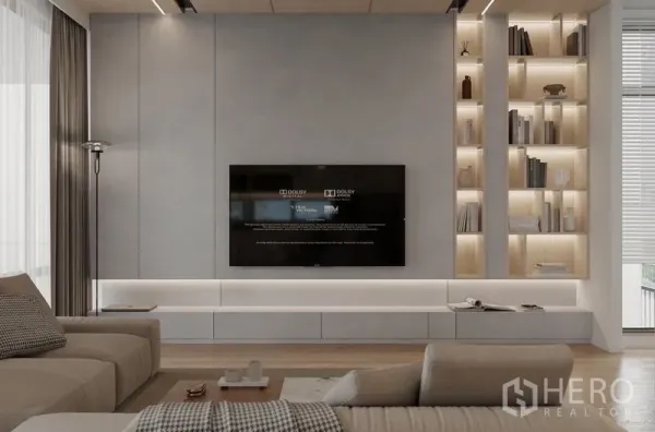 Detached House for rent in Saphan Sung, Bangkok - Minimalist living room with wall‑mounted TV and display shelves with warm lighting.