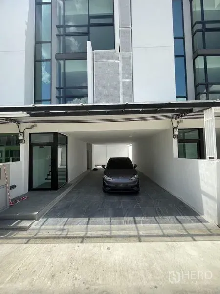 Home Office for rent in Bang Khen, Bangkok - Covered carport at the front of a home office with floor-to-ceiling windows and entry door.
