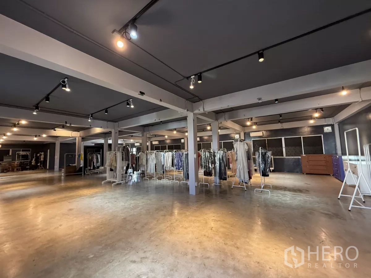 办公空间 出租在Wang Thonglang, Bangkok - 大面积工作/展厅空间，4.9米挑高，衣架陈列与水泥地，在射灯下。