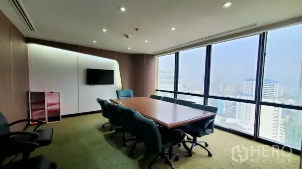 สำนักงาน ให้เช่าในWatthana, Bangkok - ห้องประชุมใหญ่ โต๊ะยาว เก้าอี้สีเขียวน้ำทะเล พร้อมกระจกเต็มบานรับวิวสกายไลน์