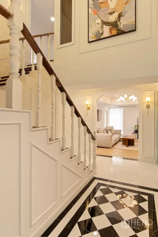 Condominium for sale in Watthana, Bangkok - Classic staircase in Watthana condominium with white balusters and black-and-white marble floor.