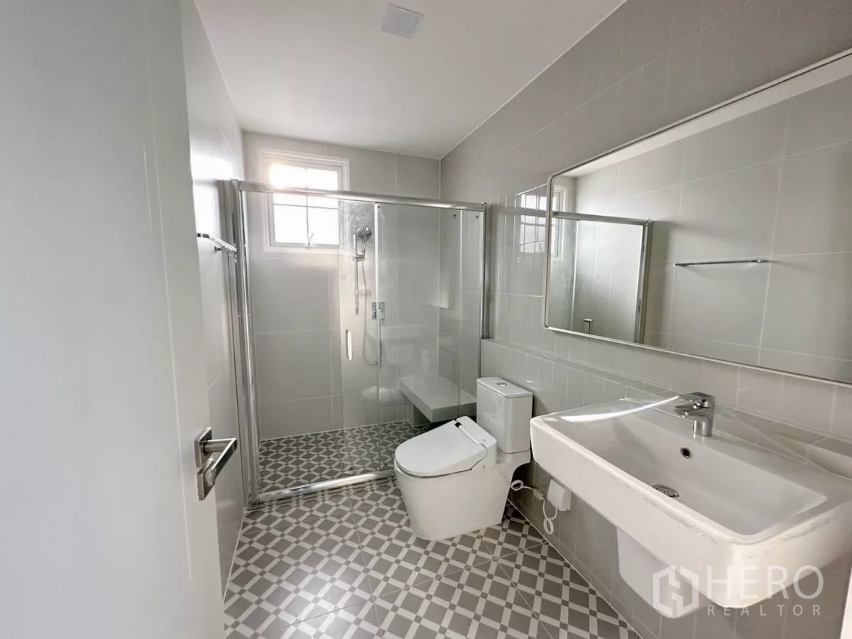 Detached House for rent in Bang Phli, Samut Prakan - Modern bathroom with glass-enclosed shower, vanity, and patterned floor tiles.