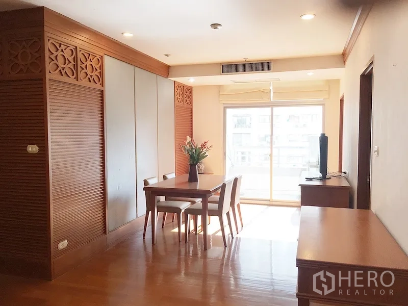 公寓 出租在Pathum Wan, Bangkok - 采光充足的客餐厅，木质装饰，四人餐桌、电视柜，推拉落地门通往阳台。