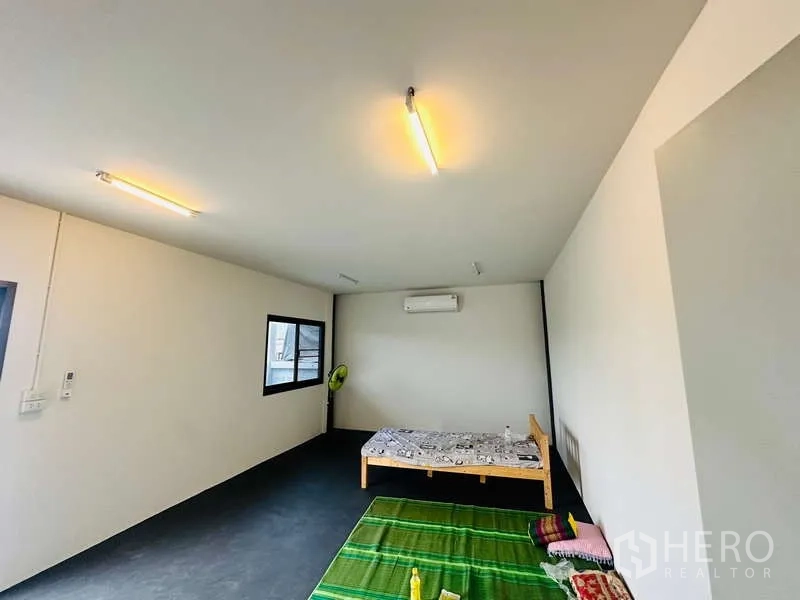 Warehouse for rent in Bang Phli, Samut Prakan - Simple staff room with air conditioning, windows and ceiling lights inside the warehouse office area.