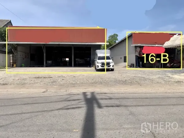 Warehouse for rent in Lam Luk Ka, Pathum Thani - Street-front warehouse with red metal roof, open drive-in bays, and a parked delivery truck in Lam Luk Ka.
