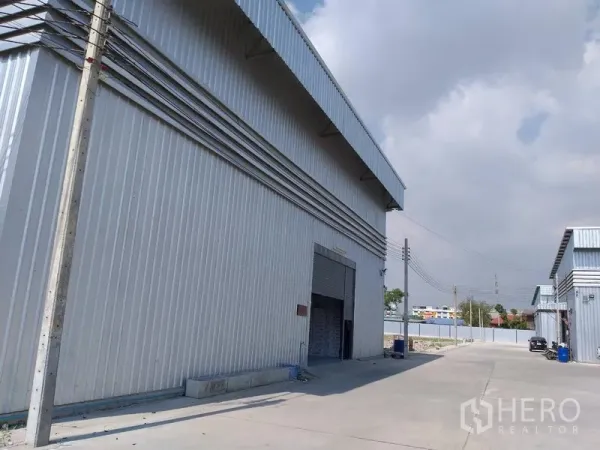 คลังสินค้า ให้เช่าในBang Phli, Samut Prakan - มุมอาคารโกดังเหล็ก พร้อมช่องโหลดสินค้าและลานกว้าง มีเสาไฟฟ้า