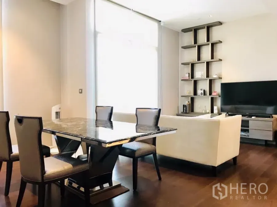公寓 出租或出售在Watthana, Bangkok - 明亮的客餐厅一体空间，带大理石餐桌、沙发、内置置物架和深色木地板