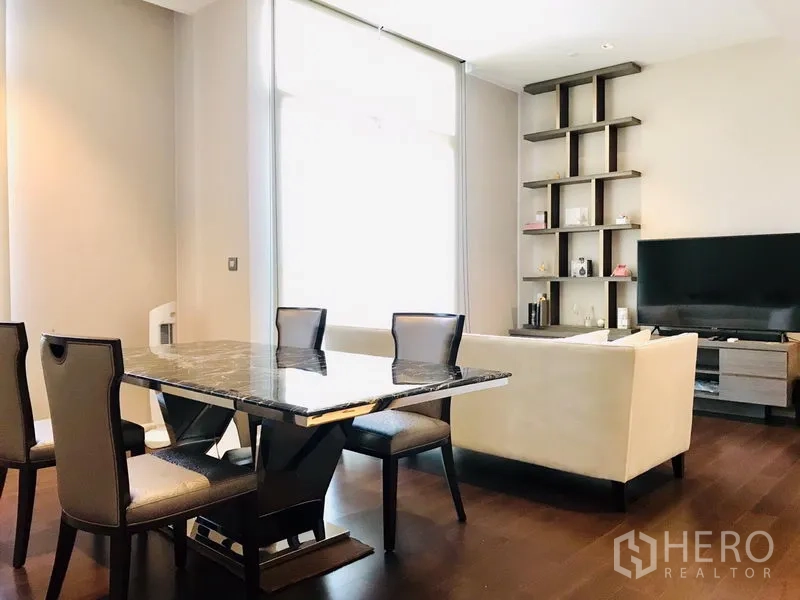 公寓 出租或出售在Watthana, Bangkok - 明亮的客餐厅一体空间，带大理石餐桌、沙发、内置置物架和深色木地板