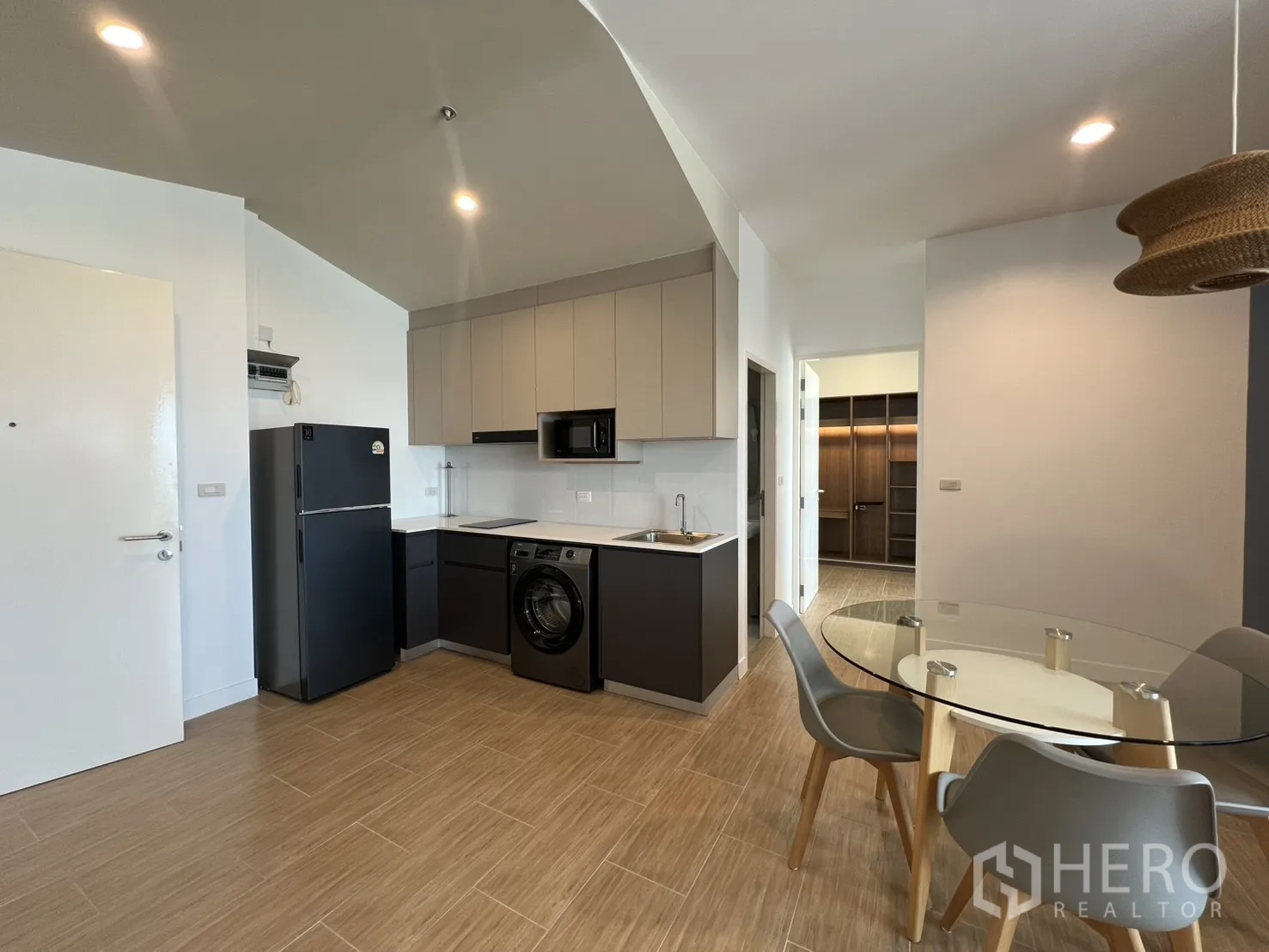 公寓 for rent in Bang Kapi, Bangkok - 厨房与餐区位于藤编吊灯下，旁有蓝色强调墙。