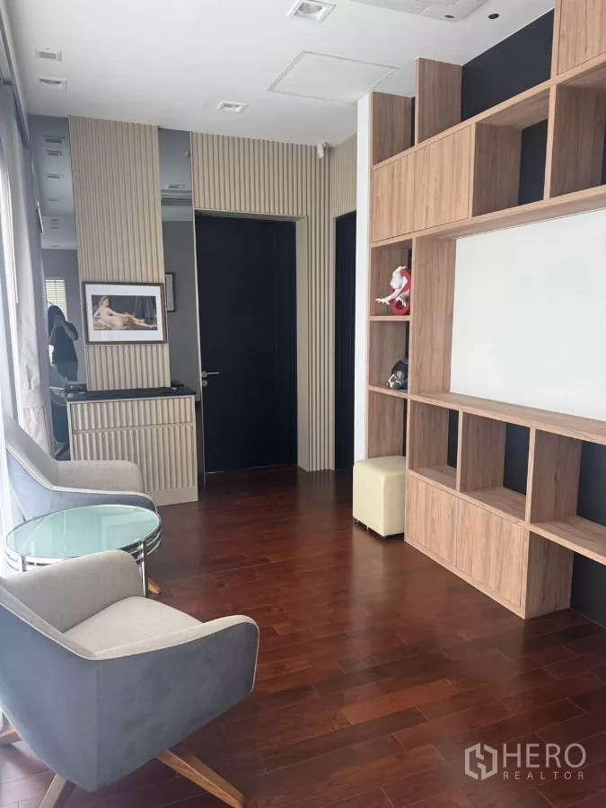 Detached House for rent in Lat Krabang, Bangkok - Sitting nook with two armchairs and a round glass table on polished wood floors.