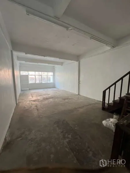 Shophouse for rent in Watthana, Bangkok - Multi-storey shophouse exterior with two balconies and ground-floor metal gate.