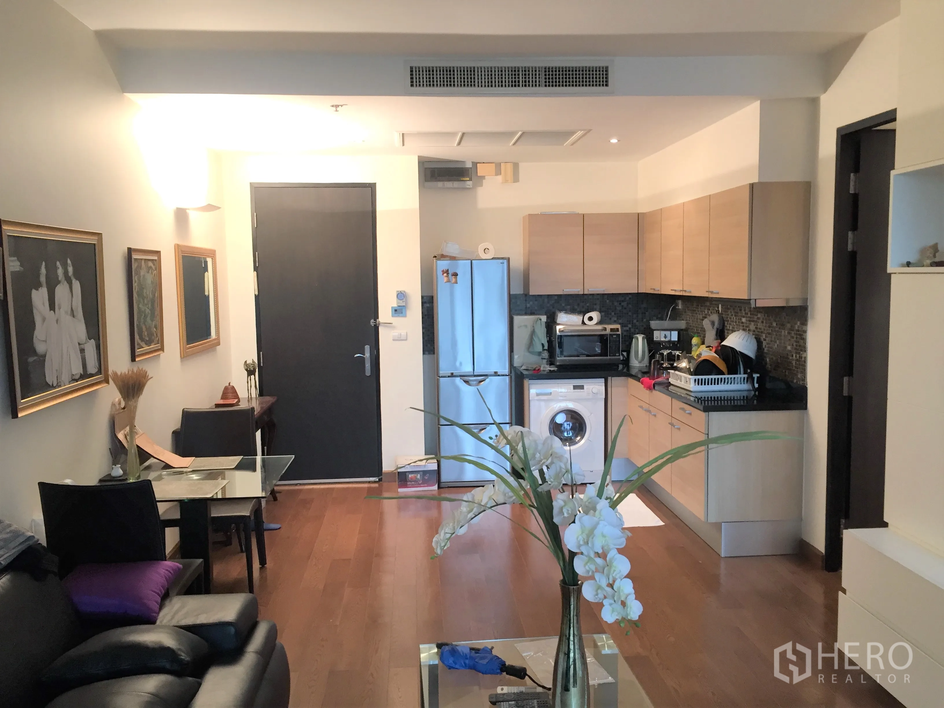 公寓 出售在Pathum Wan, Bangkok - 开放式客厅与厨房，木地板与内置橱柜电器。
