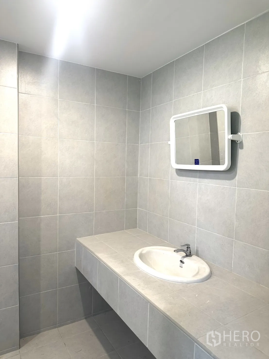 Warehouse for rent in Bang Phli, Samut Prakan - Wash area with built-in counter and basin finished in light grey tiles.