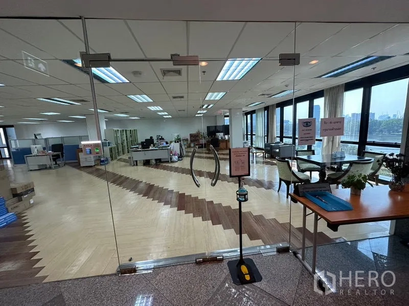 办公空间 出租在Khlong Toei, Bangkok - 玻璃双开门入口通向明亮办公室，鱼骨拼地板与园景、市景一览无余。