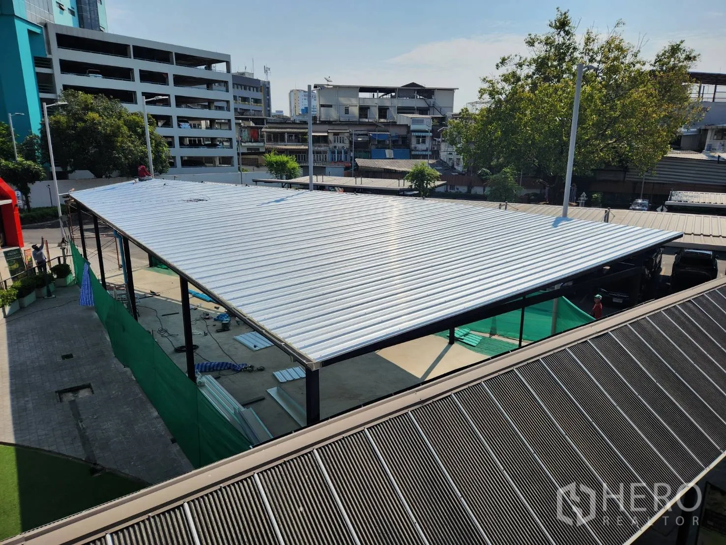 零售空间 出租在Khlong Toei, Bangkok - 俯瞰金属屋顶的商铺亭，坐落于综合体内，周边有树木与城市建筑。