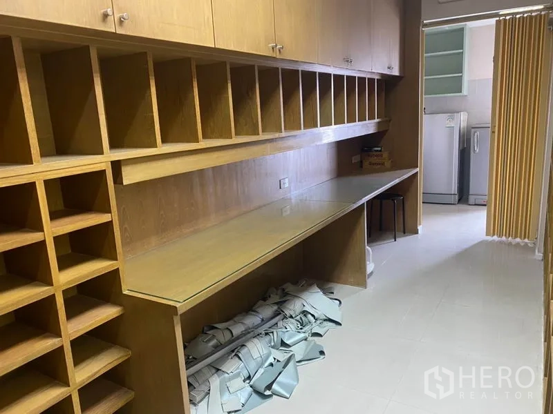 Office Space for rent in Din Daeng, Bangkok - Long storage room with wood cubby shelving and glass worktop leading to the pantry.