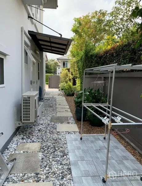 Detached House for rent in Bang Phli, Samut Prakan - Side yard service walkway with gravel, stepping stones and clothes-drying rack.