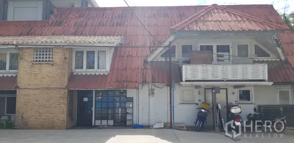 联排别墅 出租在Khlong Toei, Bangkok - 联排别墅外立面，红色瓦屋顶与小阳台，前方铺装空地。