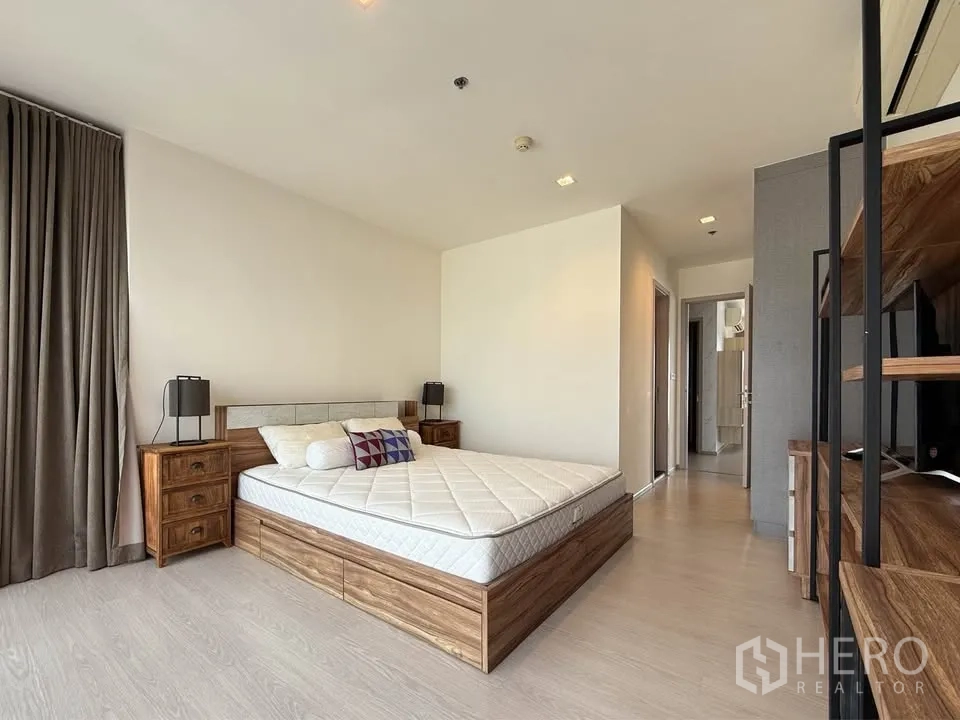 公寓 for rent in Khlong Toei, Bangkok - 木质风格房间，摆放床，视野通向走廊，装饰素雅。