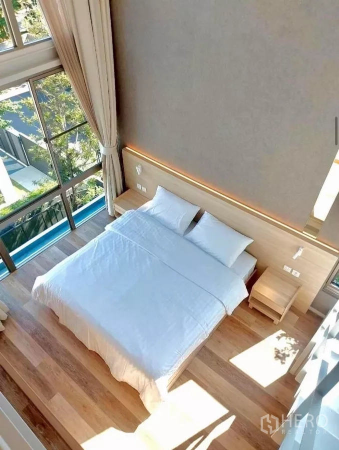 Detached House for rent in Saphan Sung, Bangkok - Top‑down view of a sunlit bedroom with large windows and wood floors.