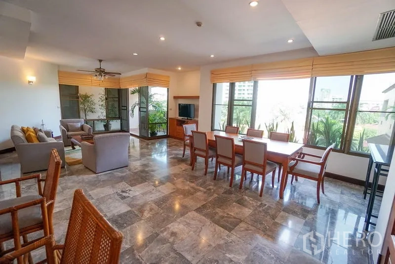 Apartment for rent in Watthana, Bangkok - Open-plan living and dining room with marble floors, large windows and leafy city views.