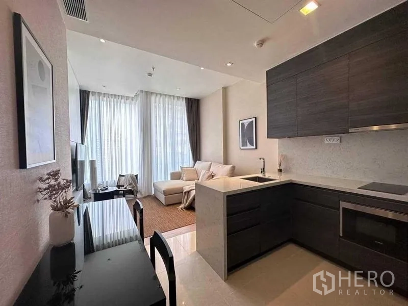 公寓 出租在Watthana, Bangkok - 开放式客厅与L型厨房，配餐桌与落地窗