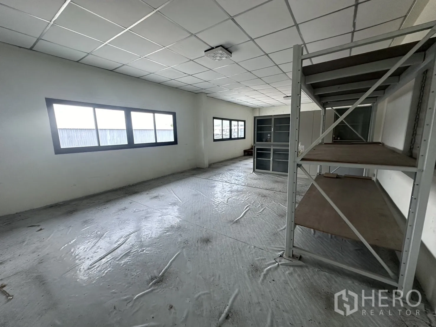 Factory for rent or sale in Prawet, Bangkok - Upstairs storage room with shelving units and natural light from windows.