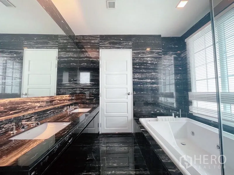 Detached House for rent or sale in Bang Phli, Samut Prakan - Luxury bathroom with black marble walls, double vanity, soaking tub, and large windows.