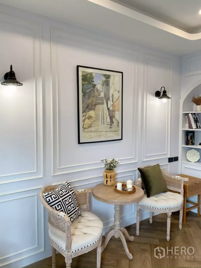 Detached House for sale in Sai Mai, Bangkok - Cozy sitting corner with two upholstered chairs and a round wooden table against paneled walls.
