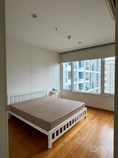 Condominium for rent in Ratchathewi, Bangkok - Bedroom with large corner windows offering Bangkok city views.