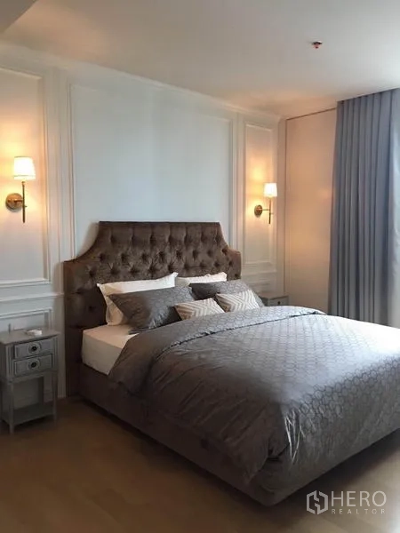 公寓 出租在Phaya Thai, Bangkok - 主卧配纽扣软包床头、壁灯与灰色床品。