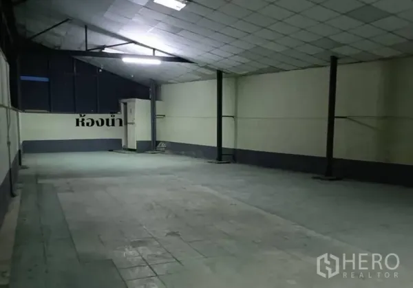 货栈 出租在Bang Khen, Bangkok - 封闭仓储间，平整吊顶与明亮照明，角落为洗手间区域。