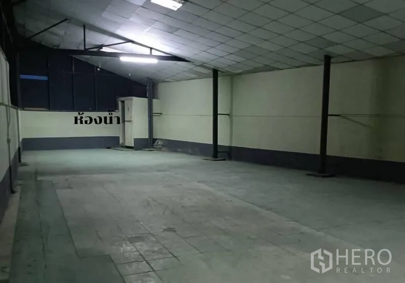 货栈 出租在Bang Khen, Bangkok - 封闭仓储间，平整吊顶与明亮照明，角落为洗手间区域。