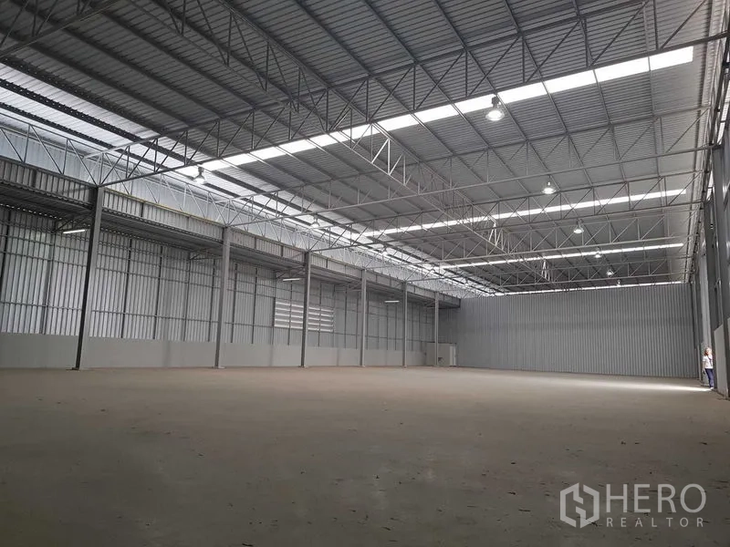 Warehouse for rent in Lat Krabang, Bangkok - Spacious high-ceiling warehouse interior with steel trusses, skylight panels and smooth concrete floor.