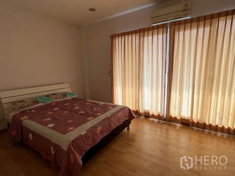 联排别墅 出租在Wang Thonglang, Bangkok - 主卧，落地窗与窗帘、壁挂空调