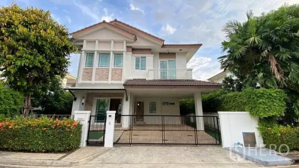 Detached House for rent in Bang Kapi, Bangkok - Two-storey detached house facade with gated driveway, balcony and mature trees.