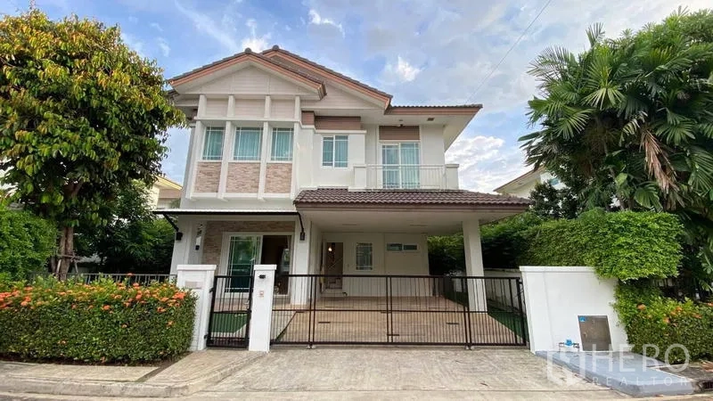 Detached House for rent in Bang Kapi, Bangkok - Two-storey detached house facade with gated driveway, balcony and mature trees.