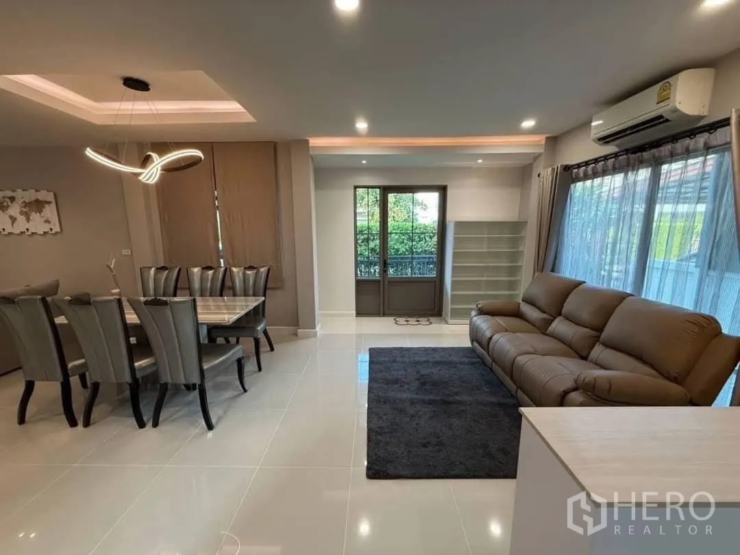 บ้านเดี่ยว for rent in Prawet, Bangkok - โถงรับแขกเชื่อมรับประทานอาหาร โซฟาหนัง แอร์ และหน้าต่างมองเห็นสวน