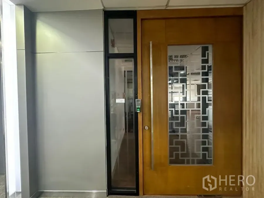 Office Space for rent in Bang Rak, Bangkok - Close-up of the office suite doorway featuring a keypad lock and decorative frosted glass panel in a commercial corridor.