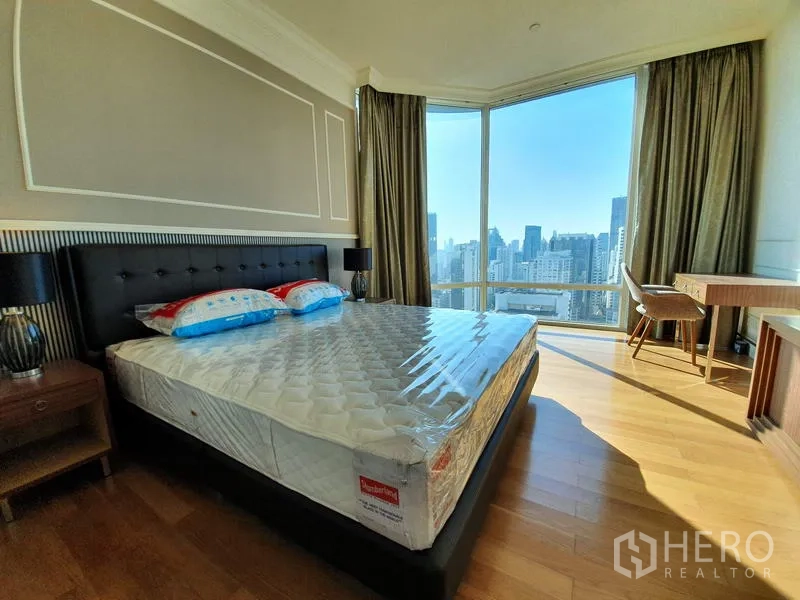 公寓 出租在Watthana, Bangkok - 主卧配落地转角窗与书桌，享开阔天际线景观。