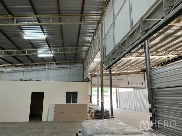 Warehouse for rent in Suan Luang, Bangkok - High-ceiling warehouse interior with steel trusses, roller shutter and an internal office in Suan Luang, Bangkok.