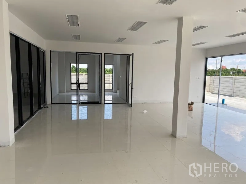 Warehouse for rent or sale in Bang Len, Nakhon Pathom - Open-plan office area with glass partitions and sliding doors connecting to an outdoor terrace.