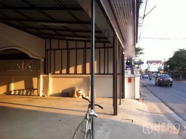 Warehouse for rent in Lam Luk Ka, Pathum Thani - Covered loading bay with a steel roof and direct road access in front of the warehouse.