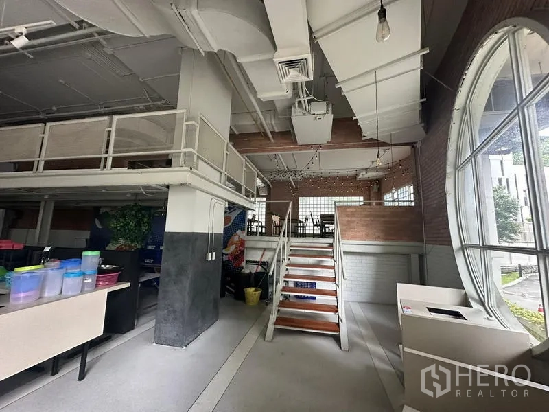 Retail Space for rent in Watthana, Bangkok - Staircase to the mezzanine beside a large circular feature window.