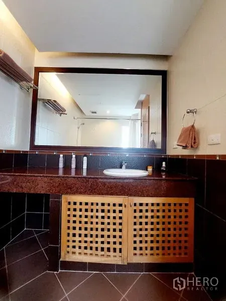 Apartment for rent - Bathroom vanity with wide mirror, stone countertop and built-in lattice cabinet.