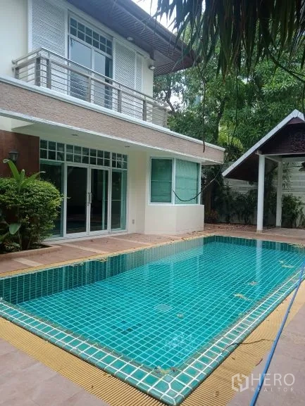 Detached House for rent in Bang Rak, Bangkok - Private turquoise-tiled swimming pool beside the house with garden patio and greenery.