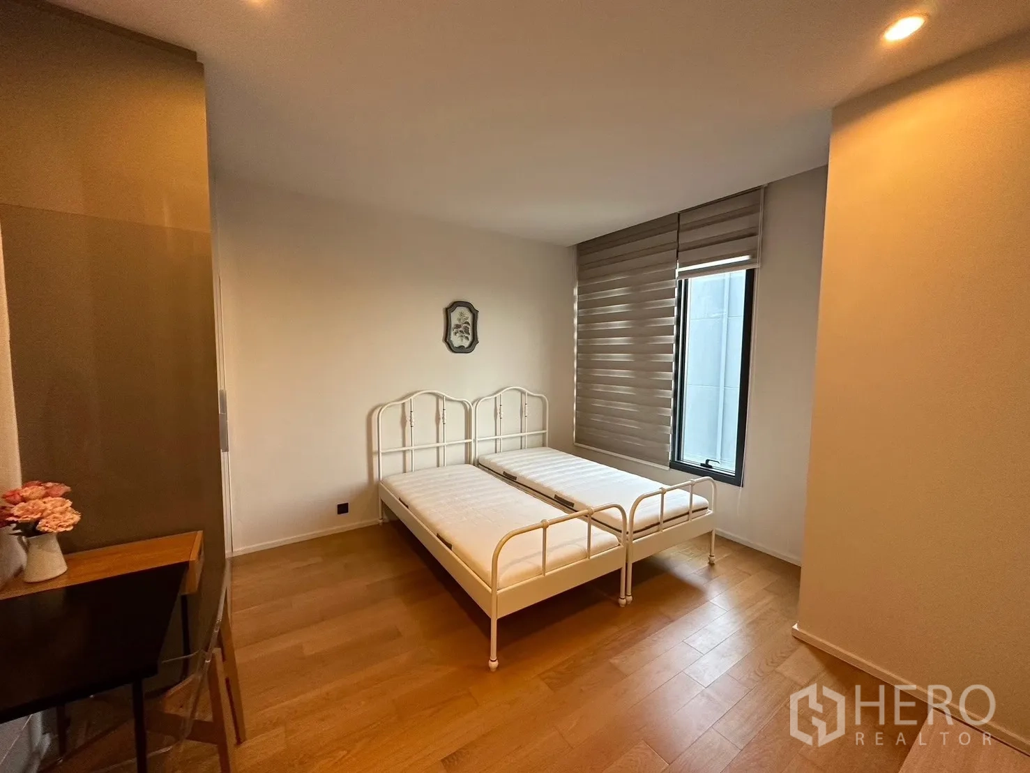 Condominium for rent or sale in Chatuchak, Bangkok - Bright bedroom with metal bedframe, window blinds, and wood flooring.