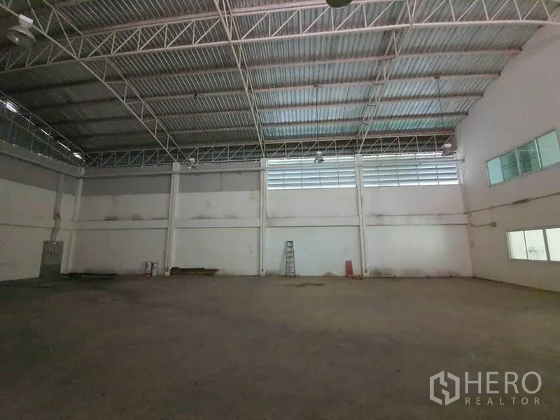 Factory for rent in Lam Luk Ka, Pathum Thani - Close view of steel truss roof, ventilation windows and industrial lighting inside the warehouse.