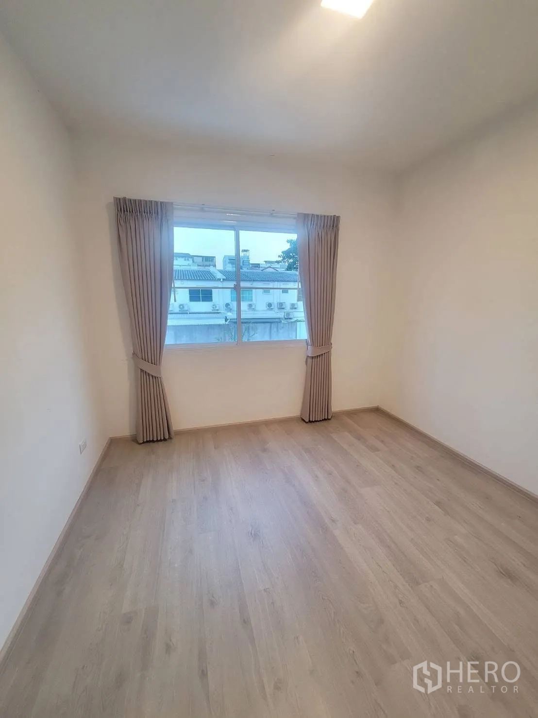 联排别墅 出租在Prawet, Bangkok - 第二卧室，浅木地板，大窗与窗帘。