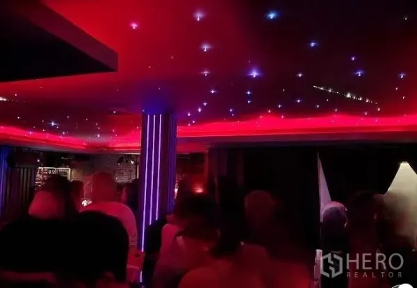 Retail Space for rent - Retail space interior with red LED ceiling and starry lights, a central column and bar area in a dark lounge setting.